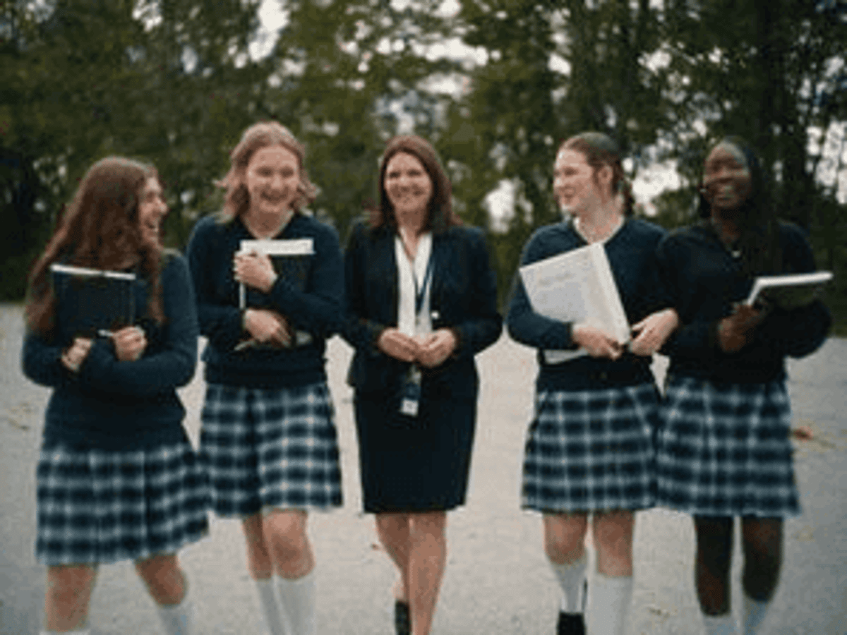 Students in uniform walking with books